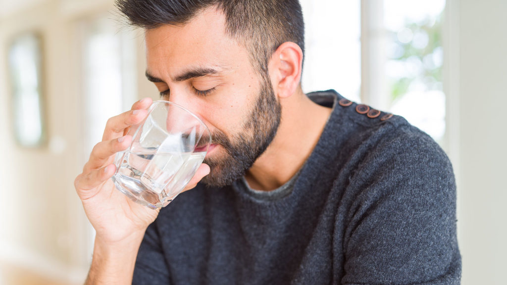Man drinking water after Gingivectomy Bissell Periodontist Chester New Jersey